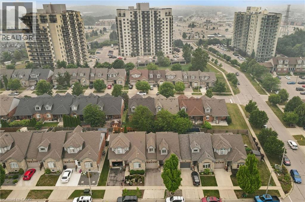 Residential neighborhood featuring a consistent architectural style across single-family homes, each with a private driveway, attached garage, and landscaped front yard - 23 Knack Lane, Cambridge, ON -