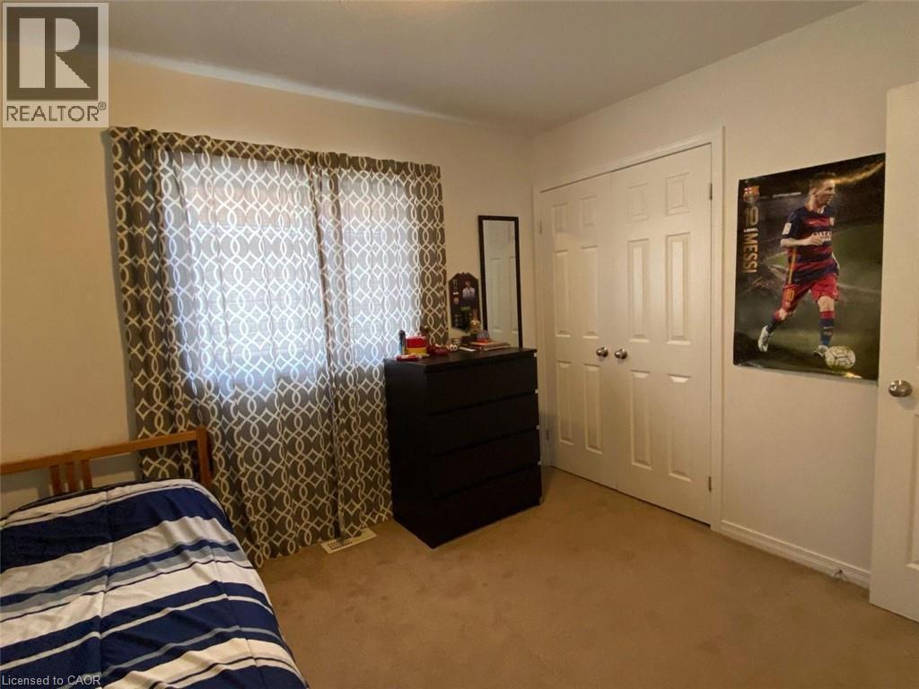 Carpeted room with a double-door closet featuring panel details and round hardware - 287 Westmeadow Drive, Kitchener, ON - Indoor Photo Showing Bedroom