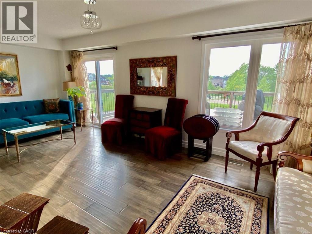 Living space with wood-finish flooring and a contemporary light fixture - 287 Westmeadow Drive, Kitchener, ON - Indoor Photo Showing Living Room