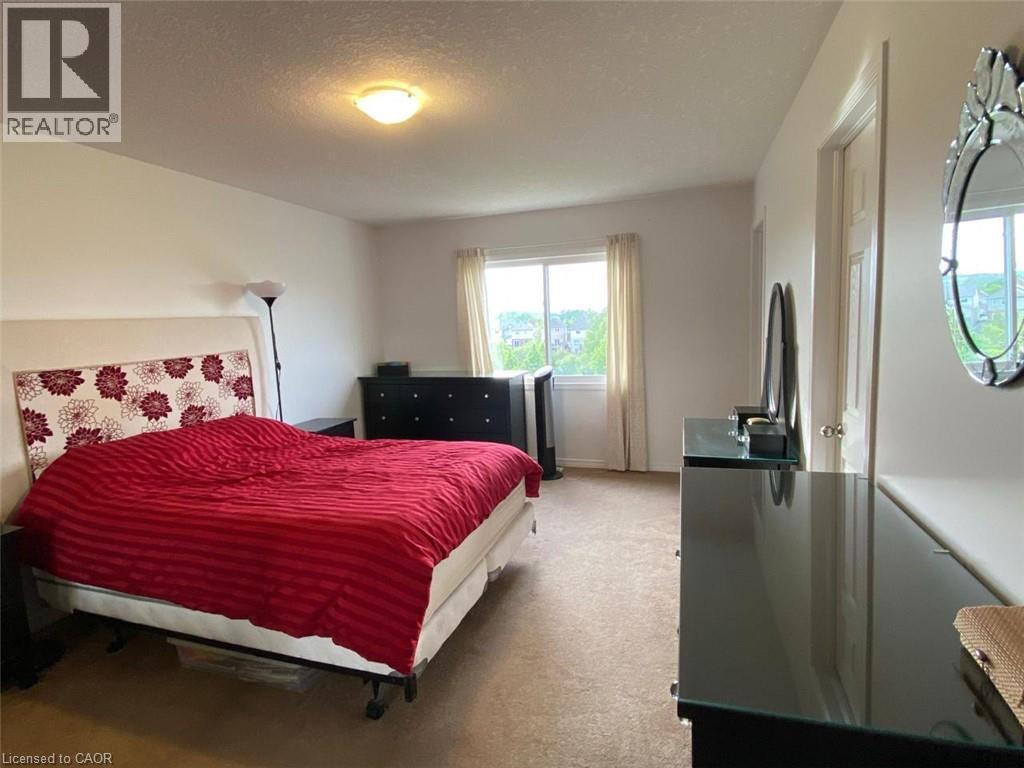 Room featuring a large window with outdoor scenery, neutral-toned walls, and a ceiling-mounted light fixture - 287 Westmeadow Drive, Kitchener, ON - Indoor Photo Showing Bedroom
