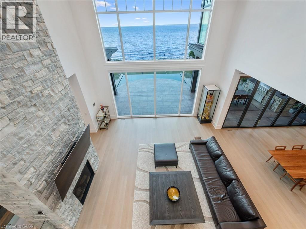 Two-story living area featuring a full-height stone fireplace with a mounted television - 140 Secord Lane, Burlington, ON - Indoor Photo Showing Other Room