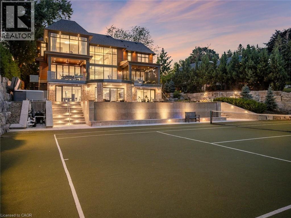 Spacious outdoor tennis court with an illuminated multi-level terraced landscape - 140 Secord Lane, Burlington, ON - Outdoor