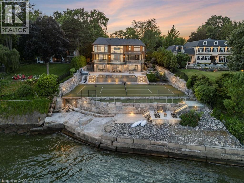 Waterfront property featuring a multi-level terraced landscape with stone retaining walls - 140 Secord Lane, Burlington, ON - Outdoor With Body Of Water With Deck Patio Veranda