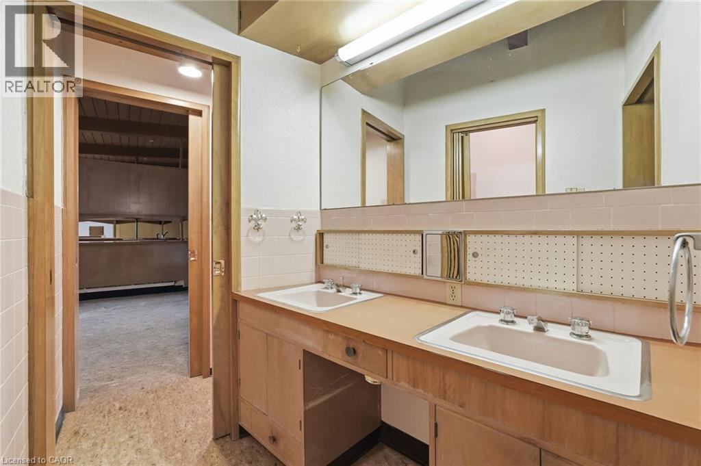Bathroom vanity featuring dual sinks, wood-finish cabinetry, and a full-width mirror - 264 Mountain Brow Boulevard, Hamilton, ON - Indoor Photo Showing Bathroom