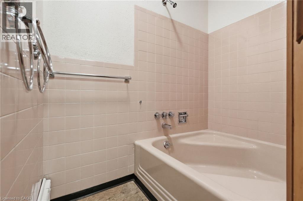 Bathroom featuring light pink wall tiling, a corner bathtub, and polished chrome fixtures - 264 Mountain Brow Boulevard, Hamilton, ON - Indoor Photo Showing Bathroom