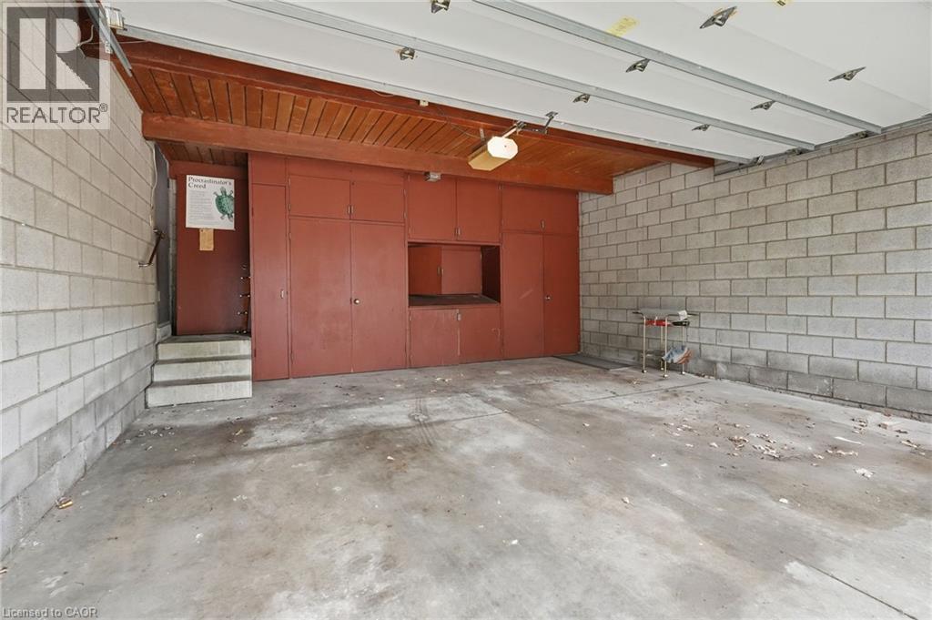 Spacious garage featuring concrete block walls, a concrete floor, and a wooden slat ceiling with exposed beams - 264 Mountain Brow Boulevard, Hamilton, ON - Indoor Photo Showing Garage