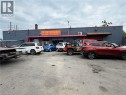 Commercial building featuring a dark gray facade with red trim and a prominent business sign - 350 Sherman Avenue N, Hamilton, ON 