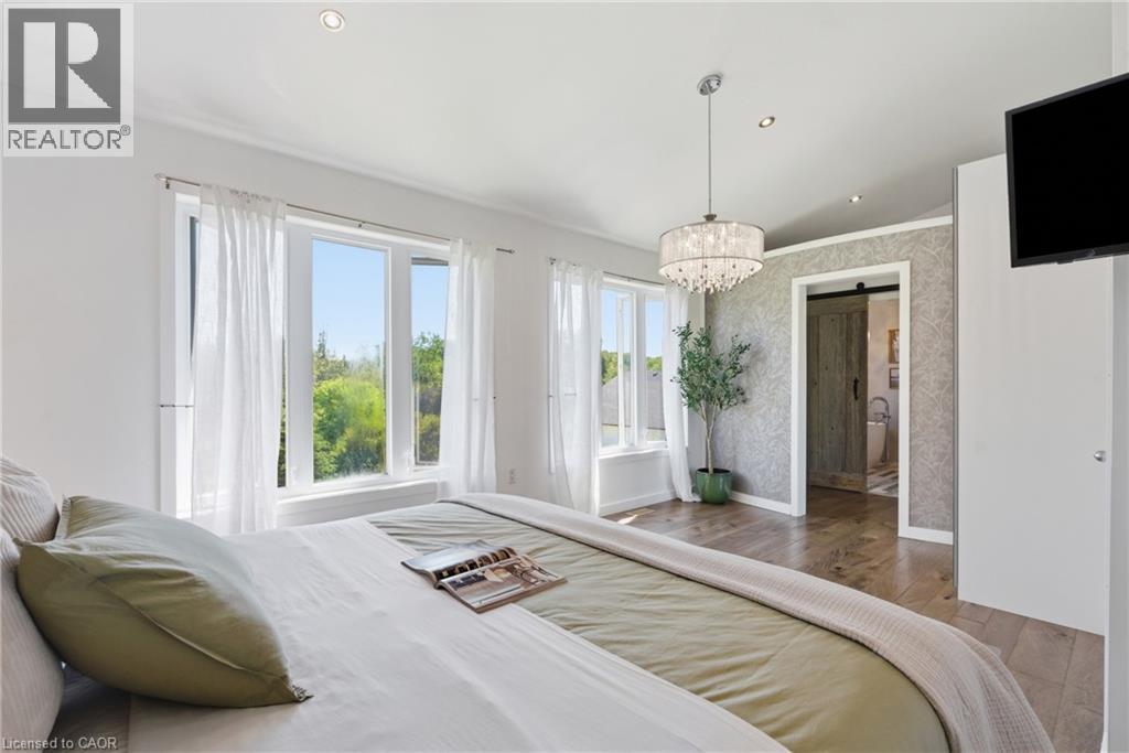 Bright room featuring multiple windows, wood-finish flooring, recessed lighting, and a crystal chandelier - 5779 Third Line, Guelph/Eramosa, ON - Indoor Photo Showing Bedroom