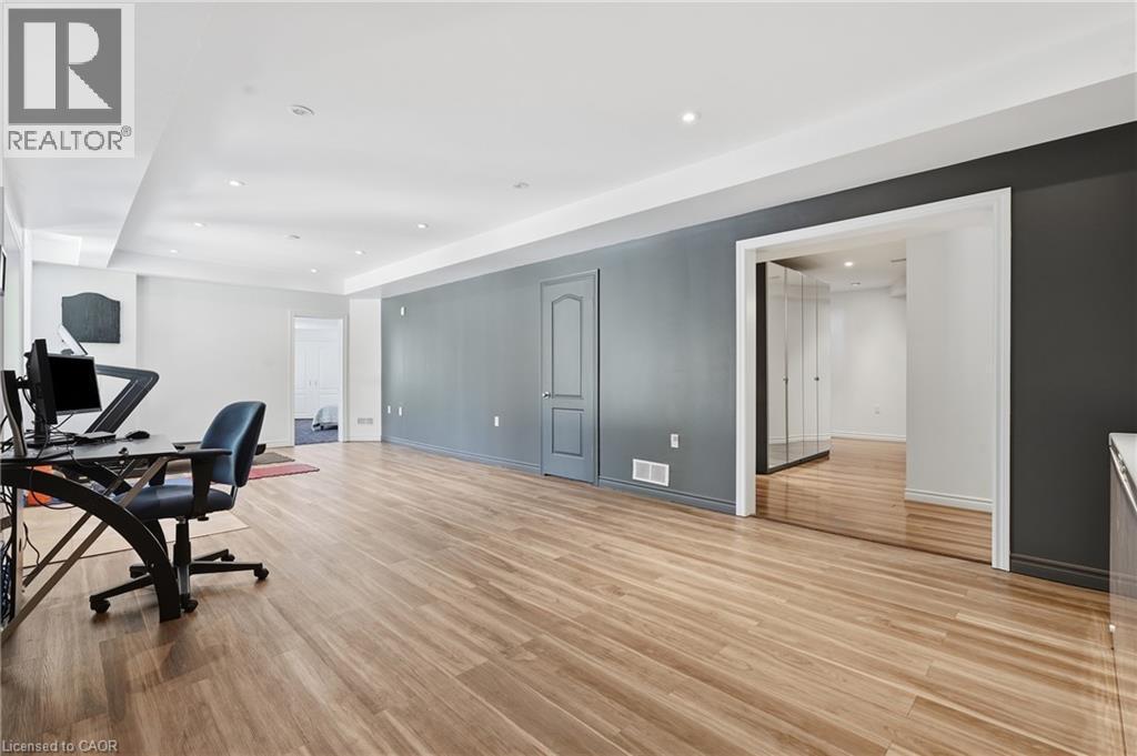 Spacious room featuring wood-finish flooring, recessed lighting, and a neutral wall color palette with an accent wall - 5779 Third Line, Guelph/Eramosa, ON - Indoor
