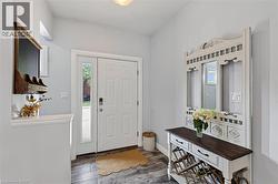 Entryway featuring a white paneled door with a sidelight, wood-finish flooring, and light gray wall paint -