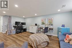 Spacious interior featuring wood-finish flooring, recessed lighting, light blue wall paint, and white baseboards -