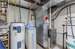 Dedicated utility area featuring a water heater, water softener, and furnace system with extensive ductwork -