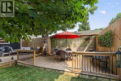 Multi-level wood deck featuring black metal balusters and a privacy fence -