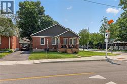 Brick exterior with contrasting dark siding and a covered front porch featuring wooden stairs -