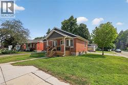 Brick exterior with stone accents, a covered front porch, and a wood-finish porch railing -