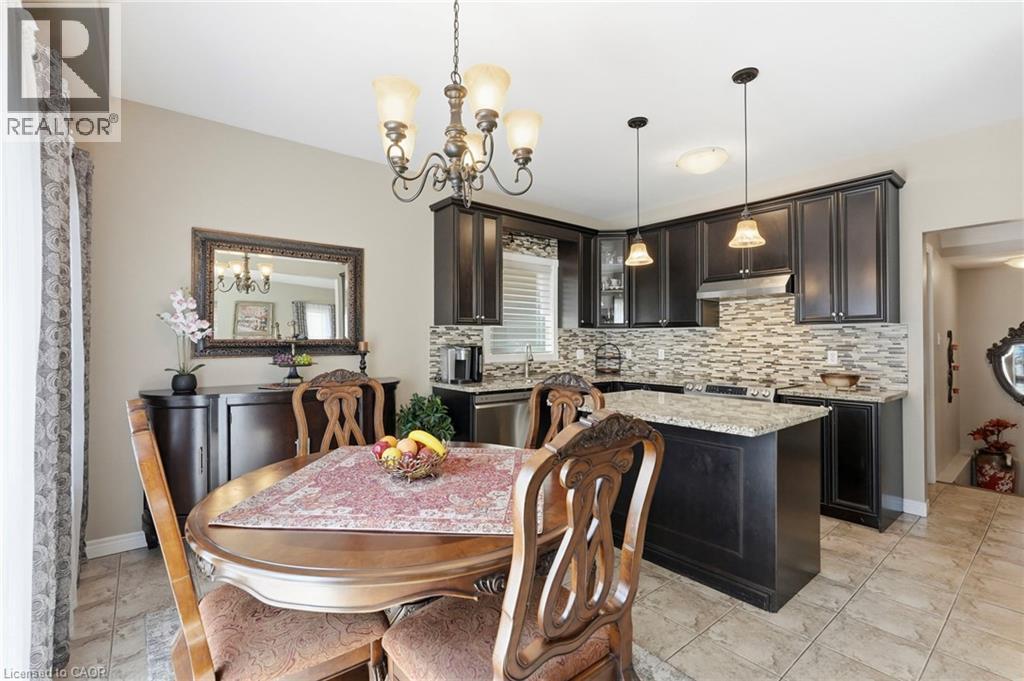 Open-concept kitchen and dining area featuring dark wood cabinetry, granite countertops, and a full-height mosaic tile backsplash - 1332 Baseline Road, Stoney Creek, ON - Indoor Photo Showing Dining Room