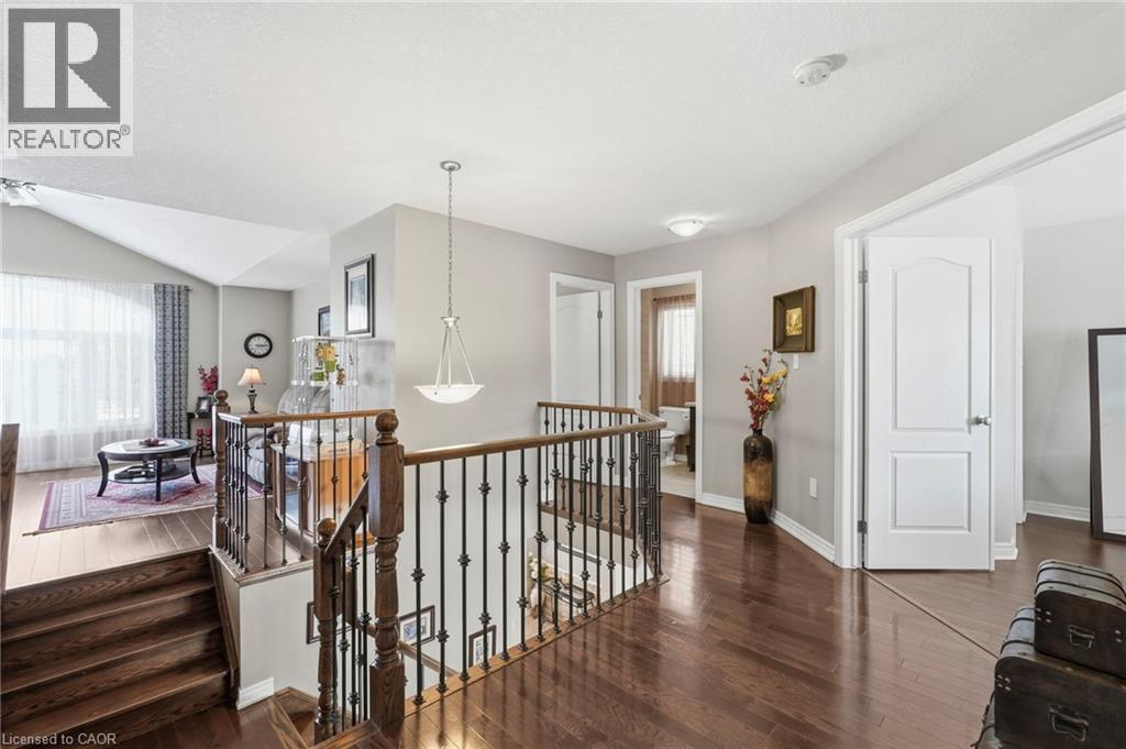 Upper-level hallway featuring rich wood-finish flooring and a staircase with dark wood railings and wrought iron spindles - 1332 Baseline Road, Stoney Creek, ON - Indoor Photo Showing Other Room