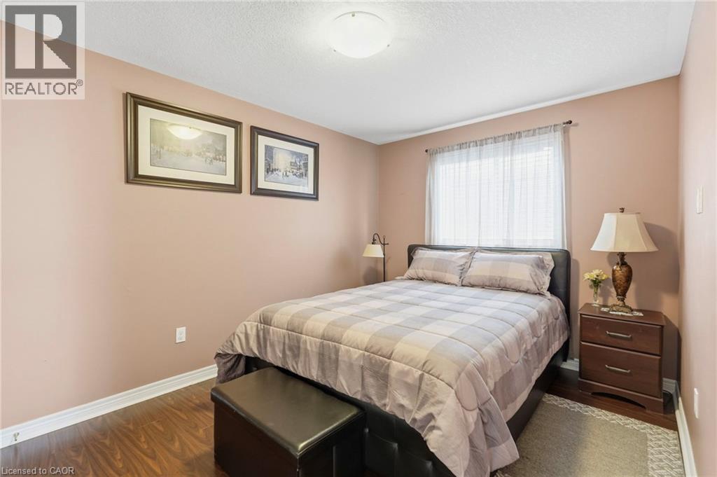Bedroom featuring wood-finish flooring, light walls, and a window with sheer curtains - 1332 Baseline Road, Stoney Creek, ON - Indoor Photo Showing Bedroom