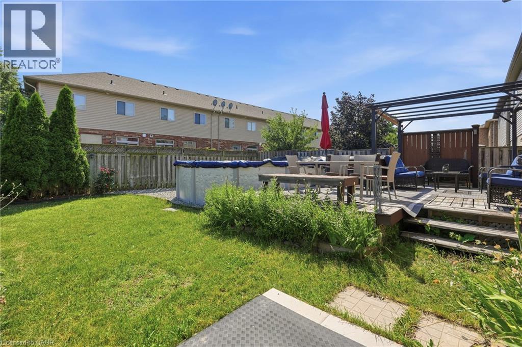 Expansive backyard featuring a spacious wood deck with pergola, above-ground pool, manicured lawn, and mature plantings - 1332 Baseline Road, Stoney Creek, ON - Outdoor