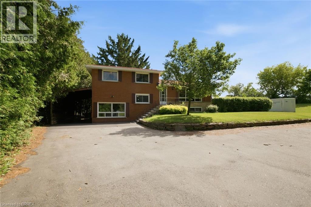 Brick residence with a prominent asphalt driveway, mature trees, and established landscaping - 1598 Highway No 6, Hamilton, ON - Outdoor
