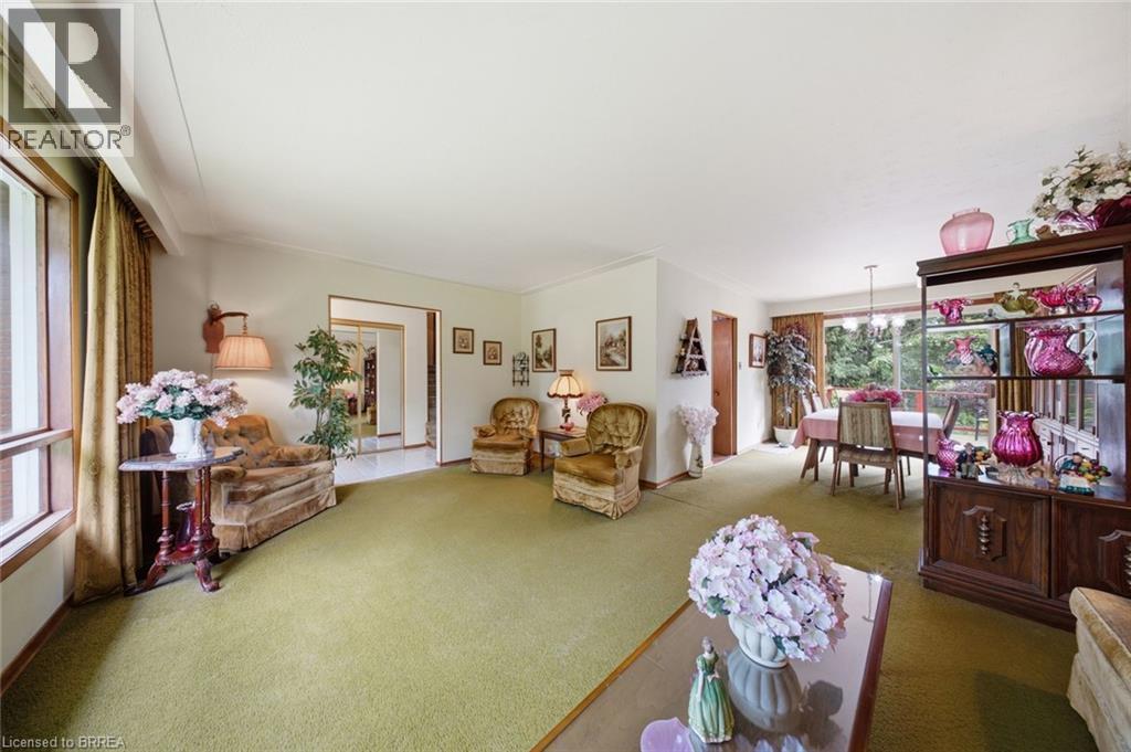 Spacious living area featuring light green carpeting and ample natural light from a large window - 1598 Highway No 6, Hamilton, ON - Indoor