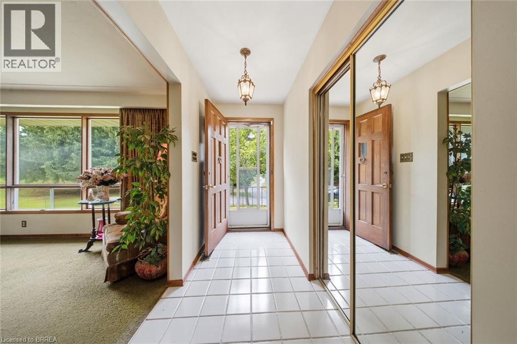 Entryway featuring white square tile flooring and two prominent paneled wood doors - 1598 Highway No 6, Hamilton, ON - Indoor Photo Showing Other Room