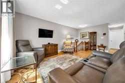 Bright living space featuring wood-finish flooring and neutral wall tones - 
