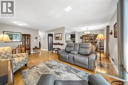Open-concept living area featuring wood-finish flooring, neutral wall tones - 