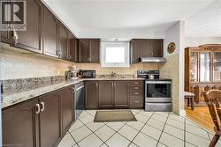 Kitchen featuring dark wood cabinetry. - 