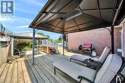 Expansive wood deck with two permanent gazebos, an elevated deck with white railings. - 
