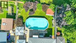 Backyard featuring an oval-shaped above-ground pool with attached wood deck - 