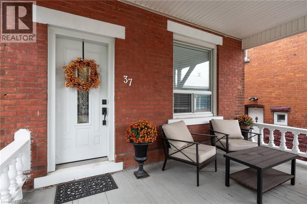 Brick exterior featuring a covered porch with a white railing - 37 Cliff Avenue Unit# Upper, Hamilton, ON - Outdoor With Deck Patio Veranda With Exterior