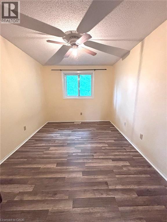 Spacious room featuring wood-finish flooring, a ceiling fan with light fixture, a window with white trim, and light-colored walls - 490 Third Street Unit# 40, London, ON - Indoor Photo Showing Other Room