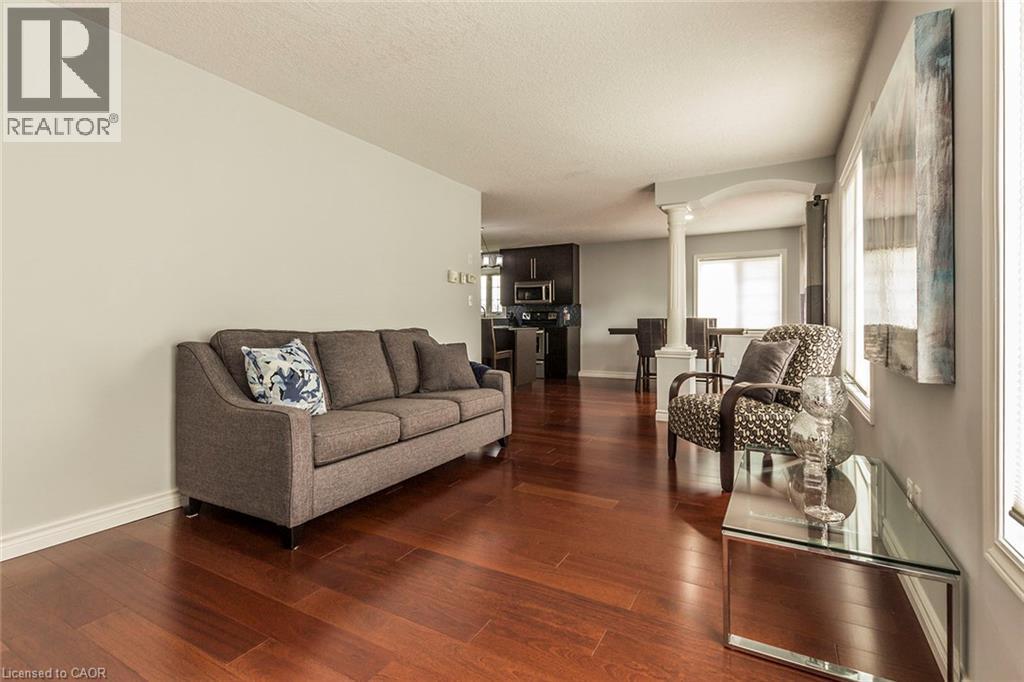 Warm wood-finish flooring extends through this open-concept living space - 44 Lemon Grass Street, Kitchener, ON - Indoor Photo Showing Living Room