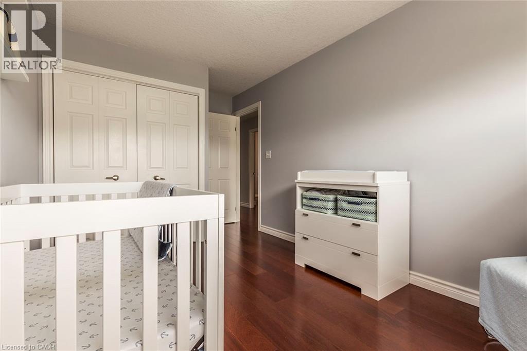 Warm wood-finish flooring complements light gray wall tones - 44 Lemon Grass Street, Kitchener, ON - Indoor Photo Showing Other Room