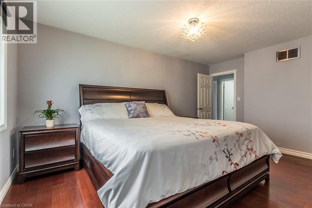 Warm wood-finish flooring complements the neutral wall color - 44 Lemon Grass Street, Kitchener, ON - Indoor Photo Showing Bedroom