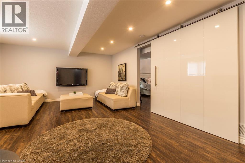 Spacious entertainment area featuring wood-finish flooring and recessed lighting - 44 Lemon Grass Street, Kitchener, ON - Indoor