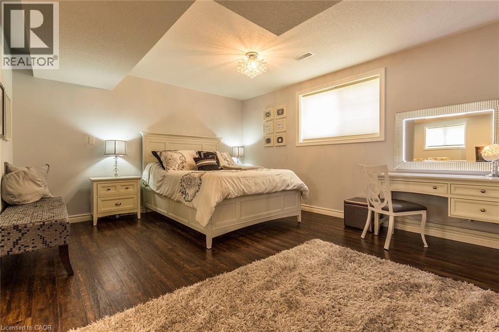 Bedroom featuring wood-finish flooring, recessed ceiling with a central light fixture, a window with a roller shade, and light-toned walls - 44 Lemon Grass Street, Kitchener, ON - Indoor Photo Showing Bedroom