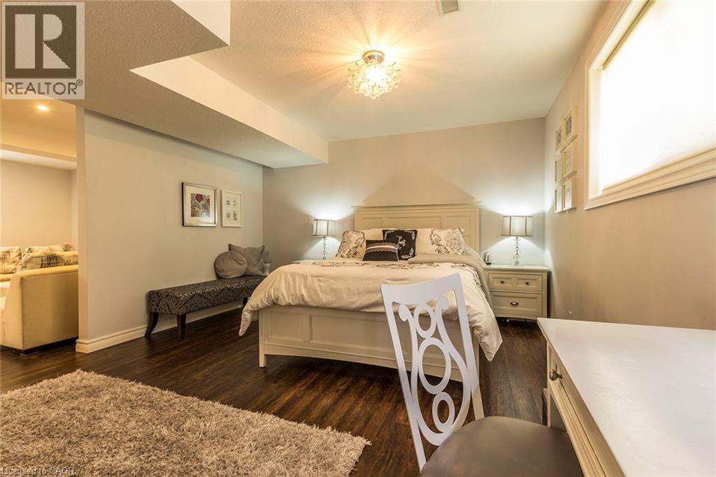 Spacious room featuring dark wood-finish flooring, light-toned walls, and a visible window with blinds - 44 Lemon Grass Street, Kitchener, ON - Indoor Photo Showing Bedroom