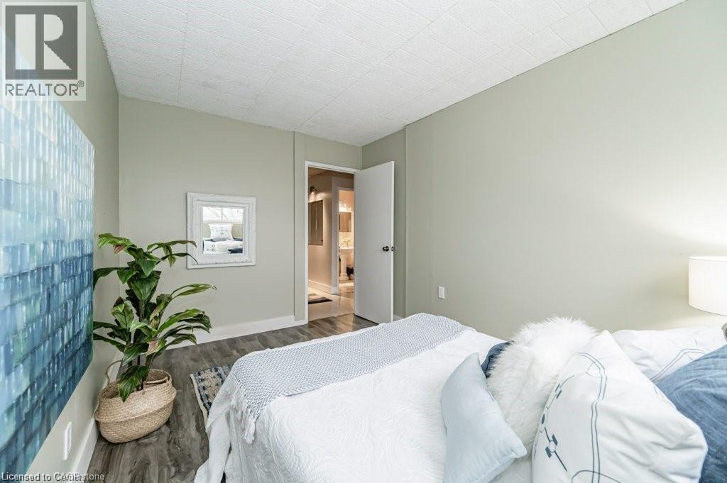 Interior room featuring light-toned walls, wood-finish flooring, and a flat white ceiling - 75 Hazelglen Drive Unit# 308, Kitchener, ON - Indoor Photo Showing Bedroom