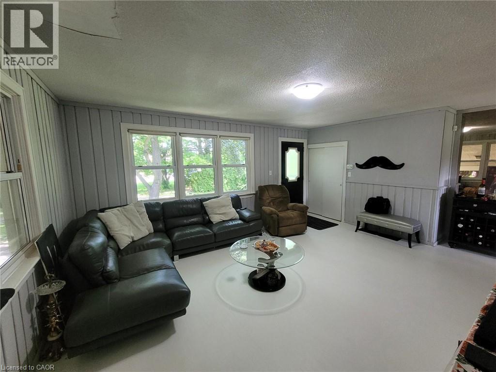 Living area featuring light-colored flooring and paneling - 879 West 5Th Street, Hamilton, ON - Indoor Photo Showing Living Room