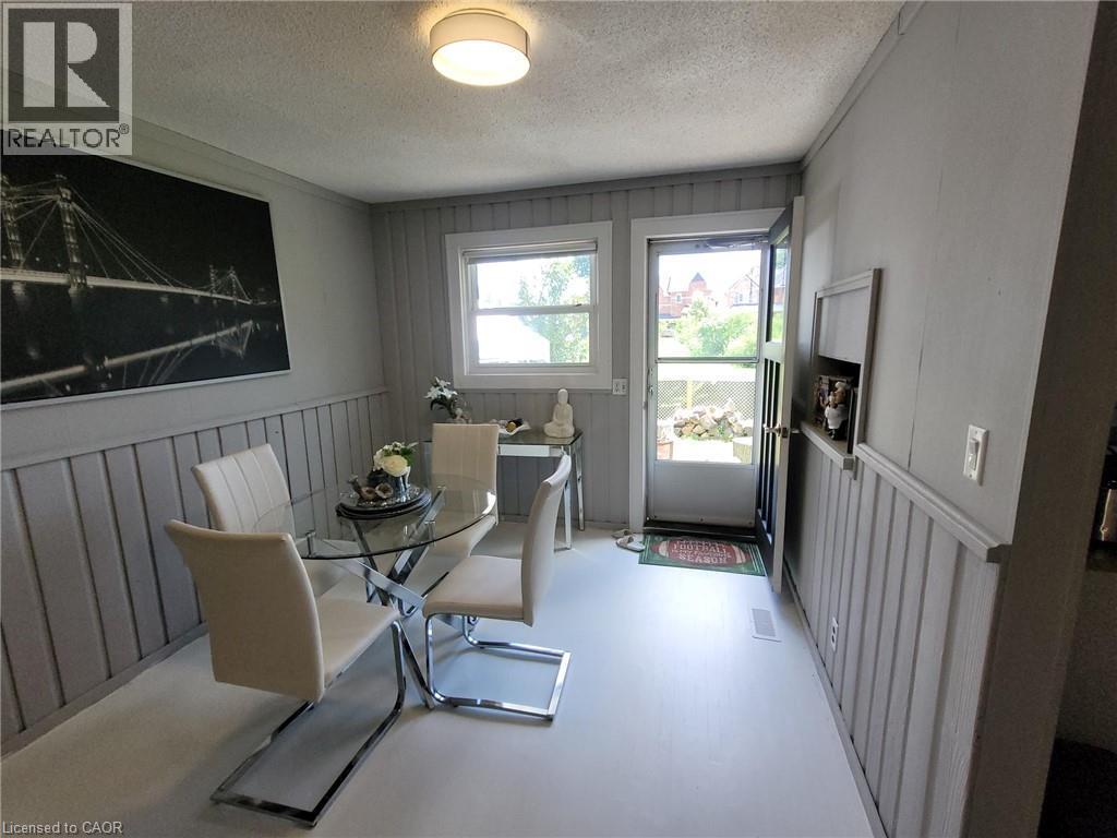 Dining area featuring painted board and batten wainscoting and light-colored flooring - 879 West 5Th Street, Hamilton, ON - Indoor Photo Showing Dining Room