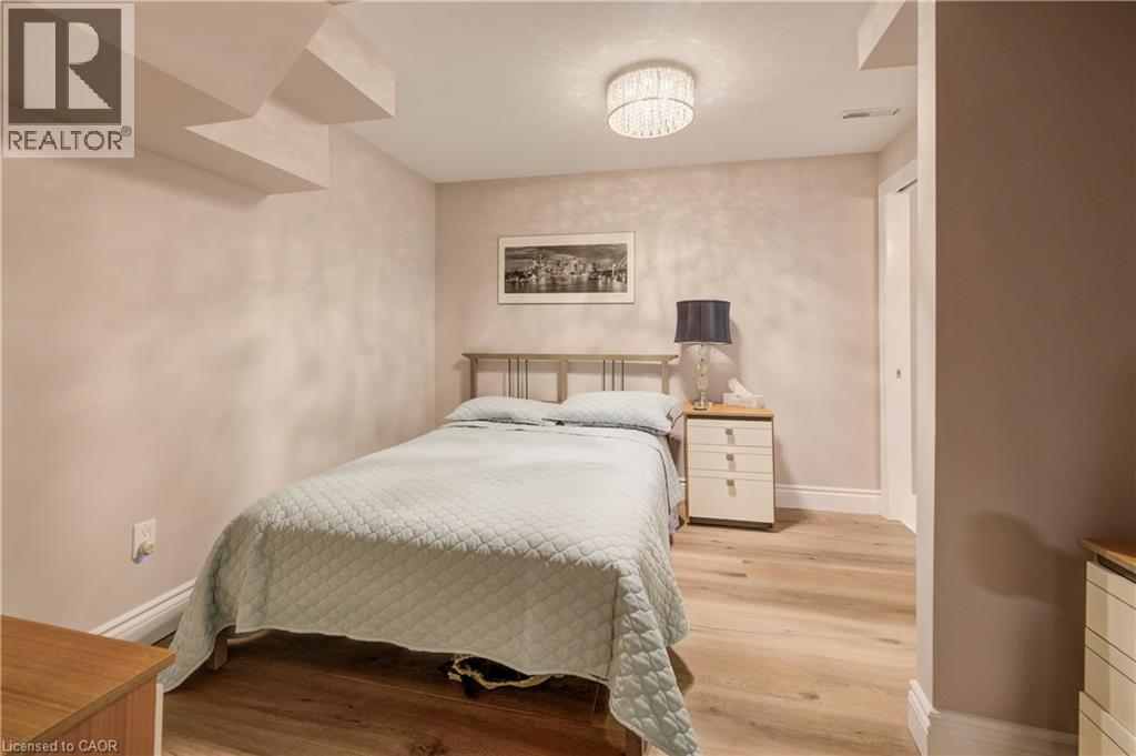 Light wood-finish flooring complements the neutral wall tones - 41 Mcniven Road, Ancaster, ON - Indoor Photo Showing Bedroom