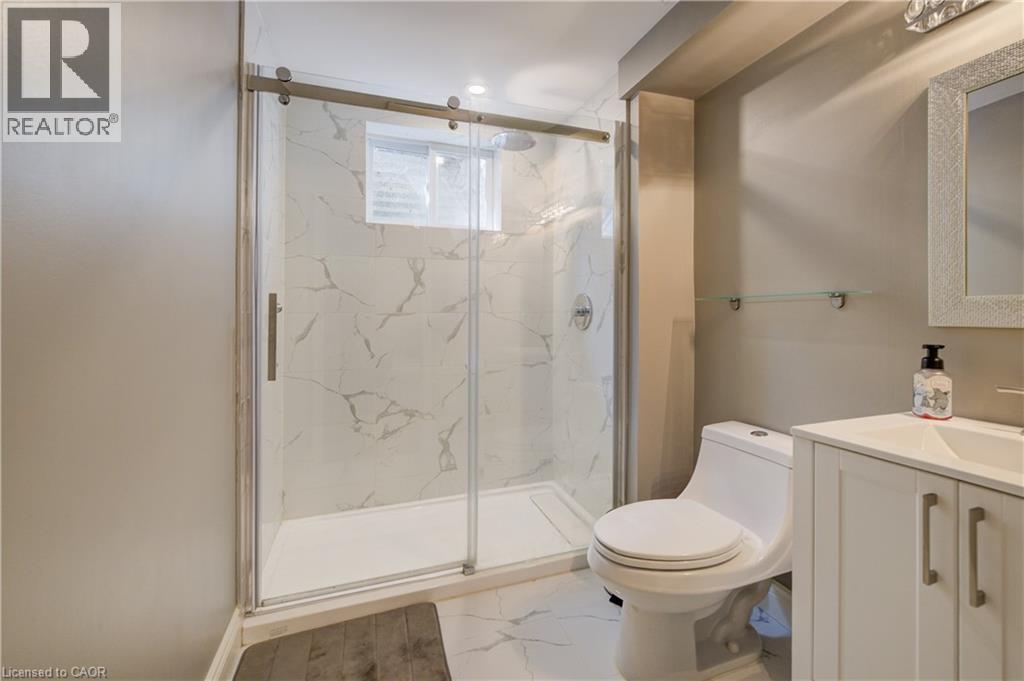 Contemporary bathroom featuring a spacious glass-enclosed shower with marble-look tile surround and a window - 41 Mcniven Road, Ancaster, ON - Indoor Photo Showing Bathroom