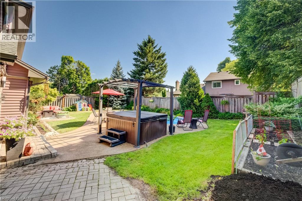Expansive backyard featuring a hot tub with pergola, an inground pool, and a fire pit area - 41 Mcniven Road, Ancaster, ON - Outdoor With Backyard
