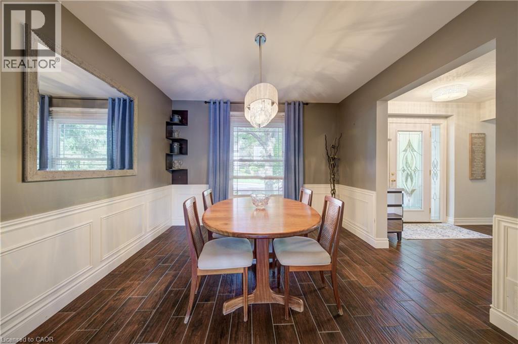 Hardwood-look flooring with white wainscoting and neutral wall paint - 41 Mcniven Road, Ancaster, ON - Indoor Photo Showing Dining Room