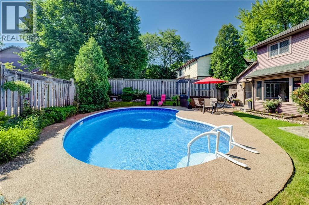 Curved inground pool with textured aggregate decking - 41 Mcniven Road, Ancaster, ON - Outdoor With In Ground Pool With Backyard
