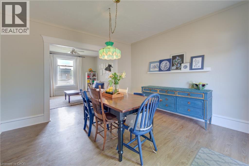 Dining area featuring wood-finish flooring, a decorative pendant light fixture, and a spacious archway - 39 Kerr Street, Cambridge, ON - Indoor Photo Showing Dining Room