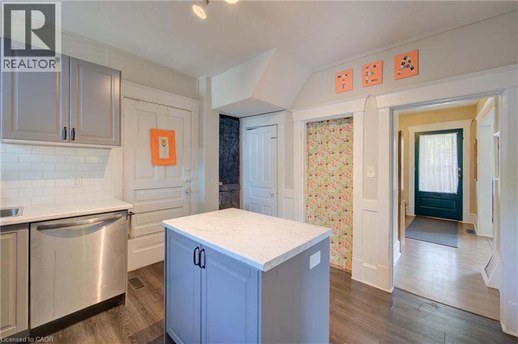 Kitchen featuring a central island with countertop, grey cabinetry, stainless steel dishwasher, and wood-finish flooring - 39 Kerr Street, Cambridge, ON - Indoor Photo Showing Kitchen