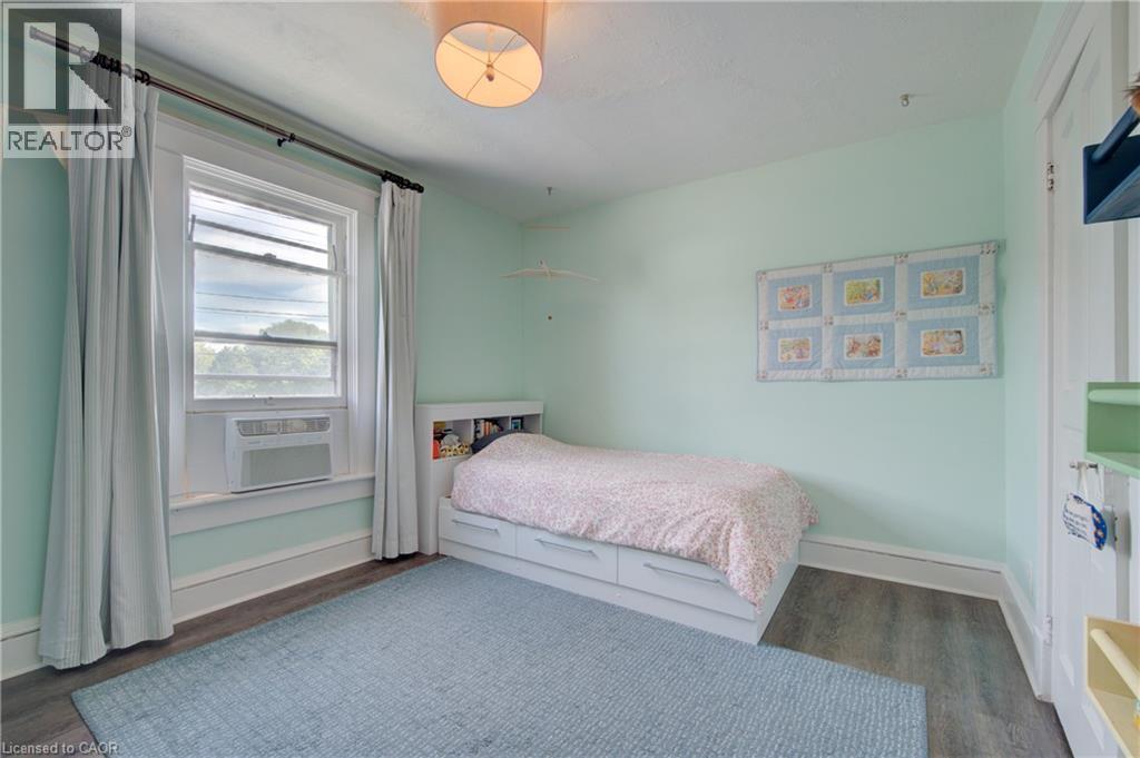 Light-filled room featuring wood-finish flooring, a window with natural light, and a ceiling-mounted light fixture - 39 Kerr Street, Cambridge, ON - Indoor Photo Showing Bedroom